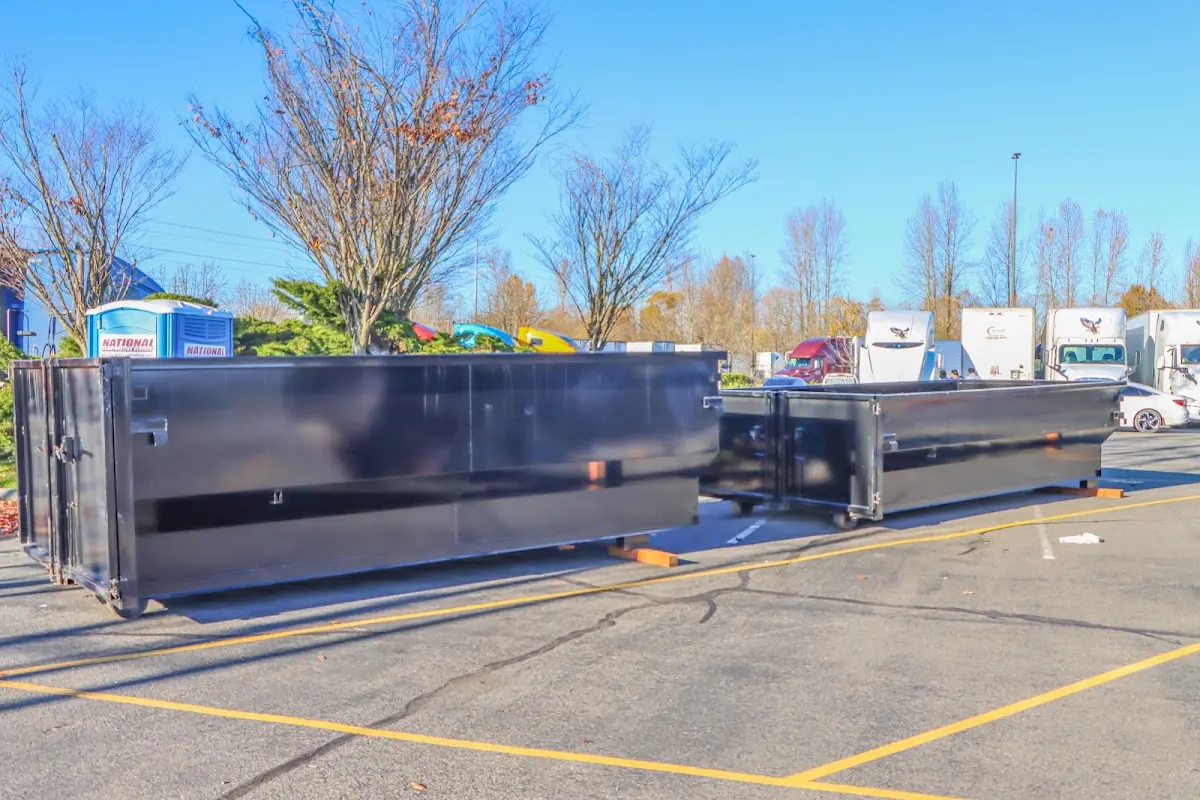 Professional dumpster rental service with roll-off container on residential driveway in Plainview